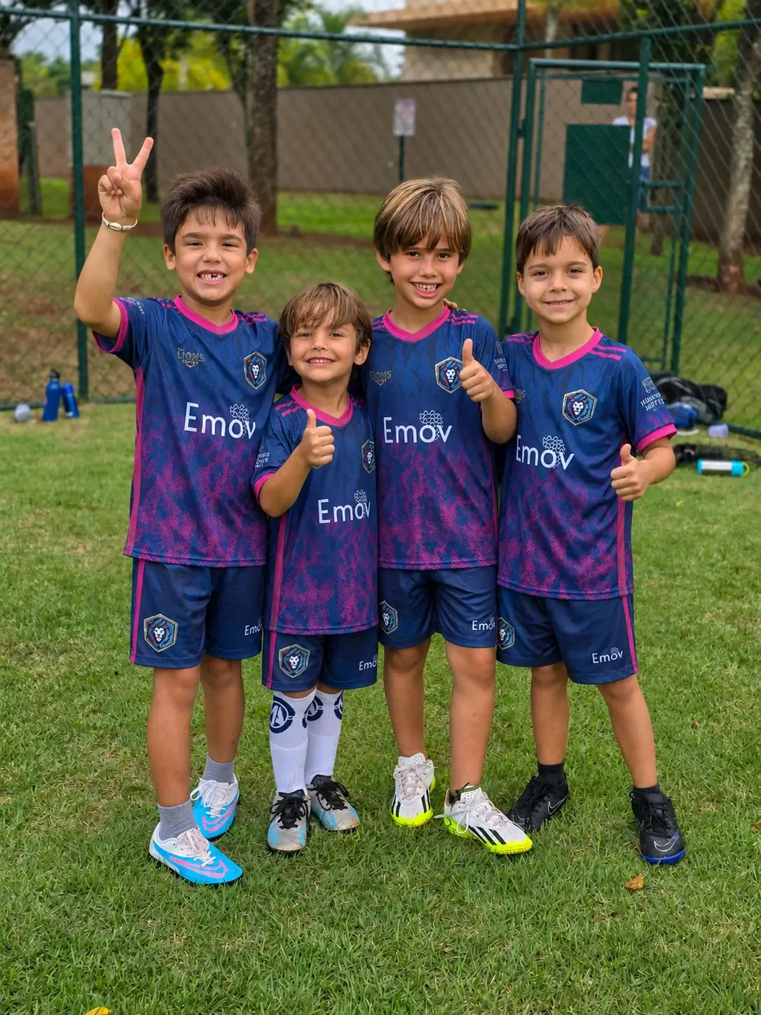 Crianças com o uniforme da M.A Lions Soccer reunidas no campo