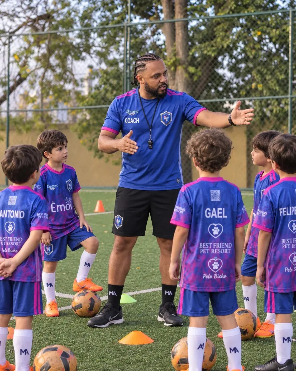 Professor orientando crianças durante um treino de futebol