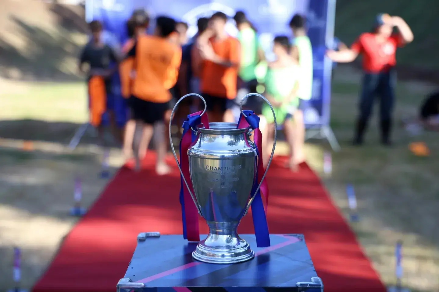 Troféu sobre uma mesa com participantes ao fundo
